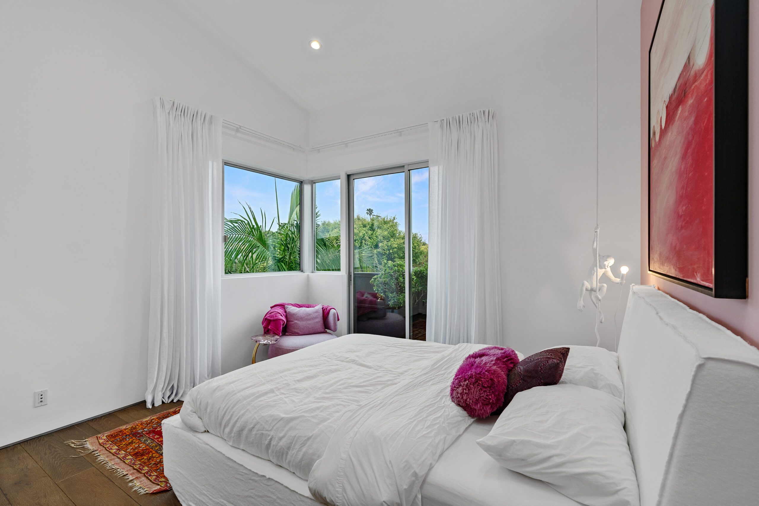 This cozy and cute bedroom includes plenty of natural light and a private balcony.