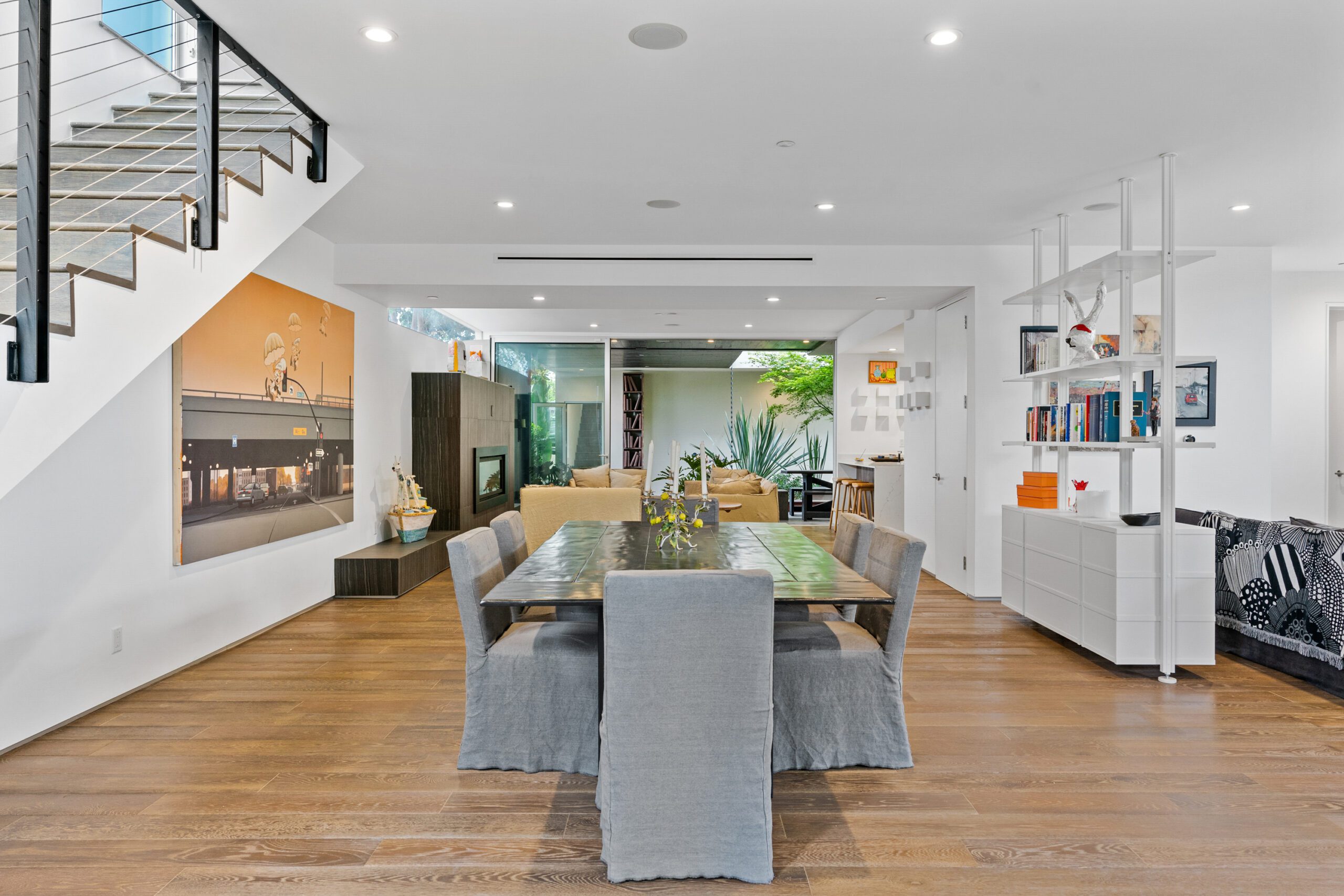 The open layout design creates flow between multiple living rooms, the dining area, and kitchen.